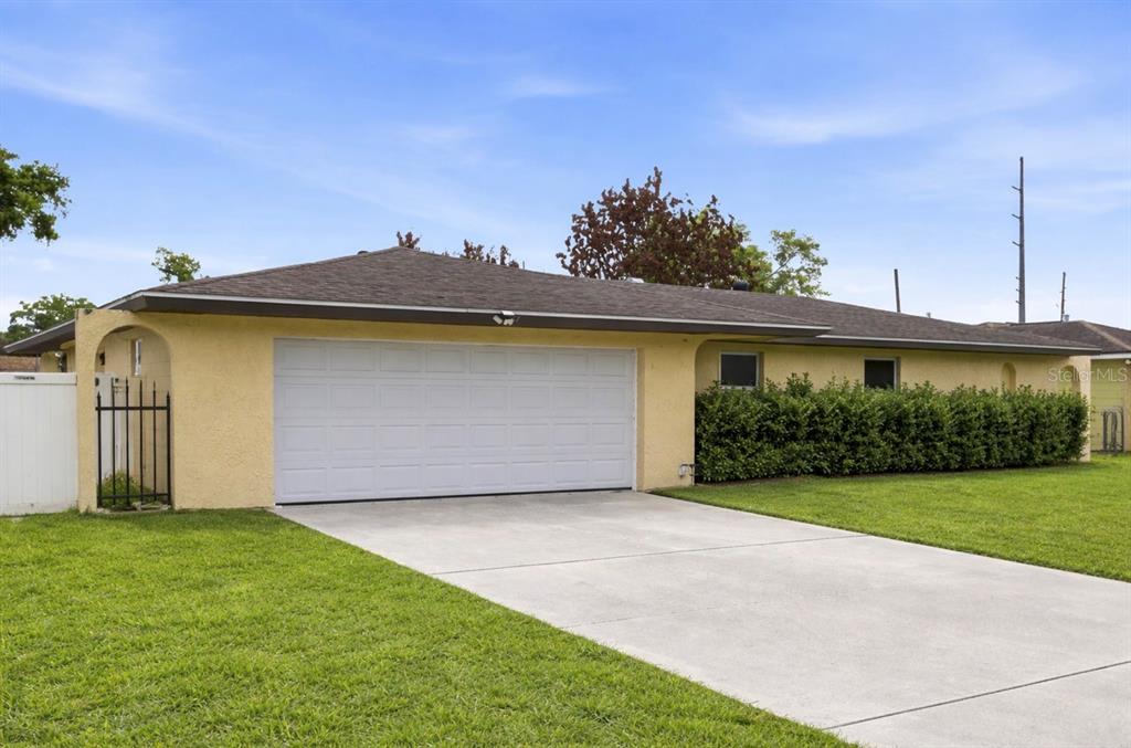 A yellow, single-story house with a white garage door and a large front lawn — 4623 CONWAY GARDENS ROAD, ORLANDO, FL