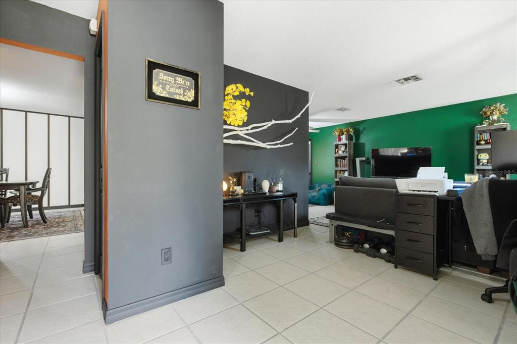 A living room features a green accent wall, a dark gray wall, and tiled flooring — 4623 CONWAY GARDENS ROAD, ORLANDO, FL