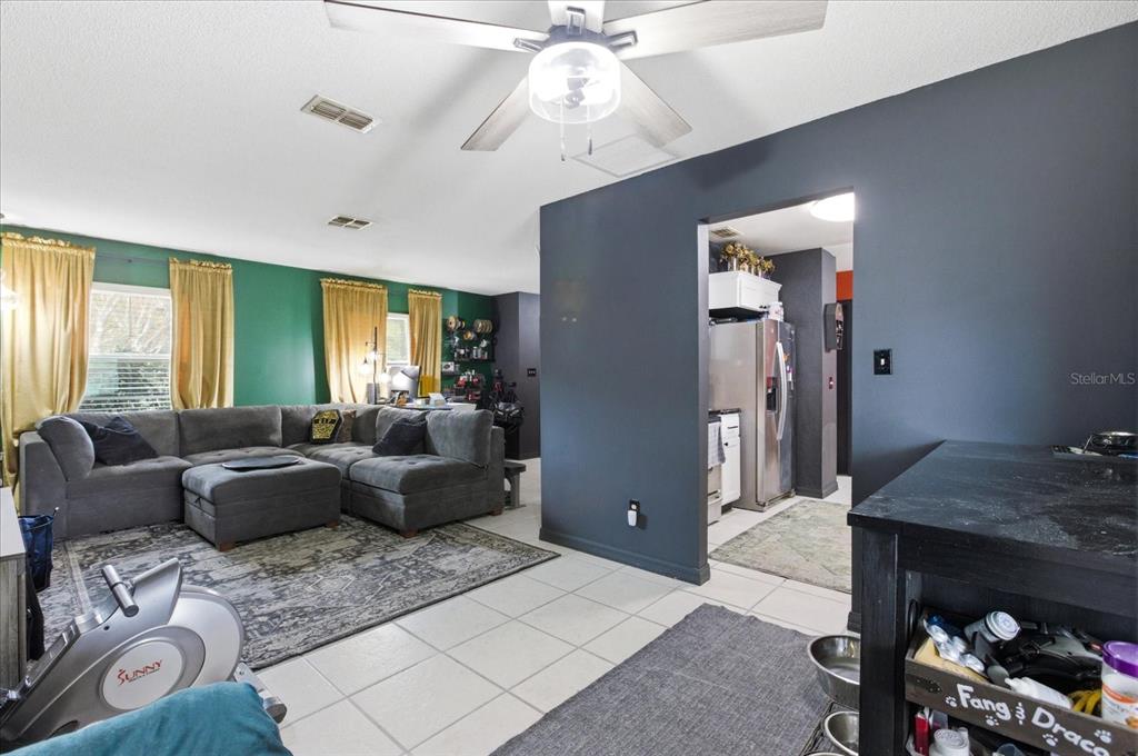 A living room with a gray sectional, green walls, and an adjacent kitchen area — 4623 CONWAY GARDENS ROAD, ORLANDO, FL