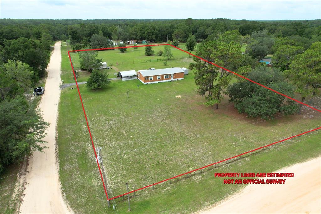 An aerial view shows a single-story house on a large, grassy lot with red boundary lines — 107 GREEN OAK DRIVE, MELROSE, FL