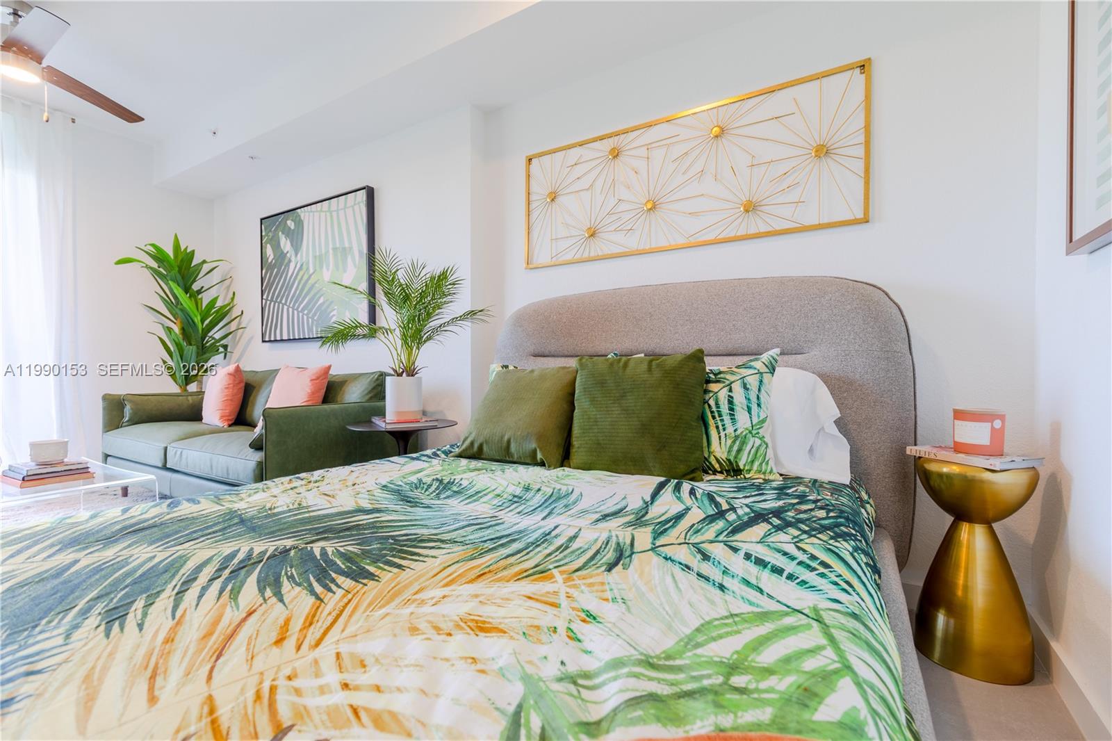A bedroom features a bed with palm-print bedding, a green sofa, and gold wall decor — 1005 Spring Garden Rd # 748, Miami FL 33136, MIAMI, FL