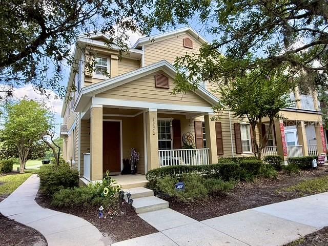 A two-story tan house with a covered front porch and a concrete walkway — 10378 LAKE DISTRICT LANE UNIT 2B, ORLANDO, FL