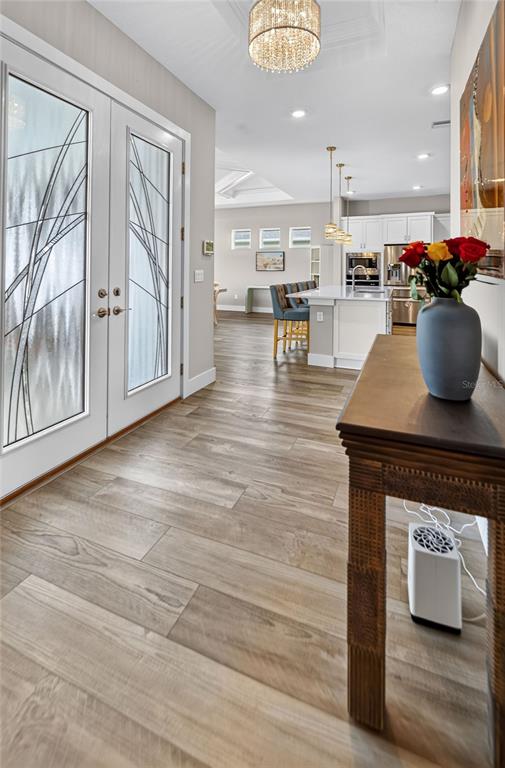 An entryway leads into an open-concept kitchen with light wood-look flooring and a central island — 10470 PURPLE THISTLE WAY, SAN ANTONIO, FL