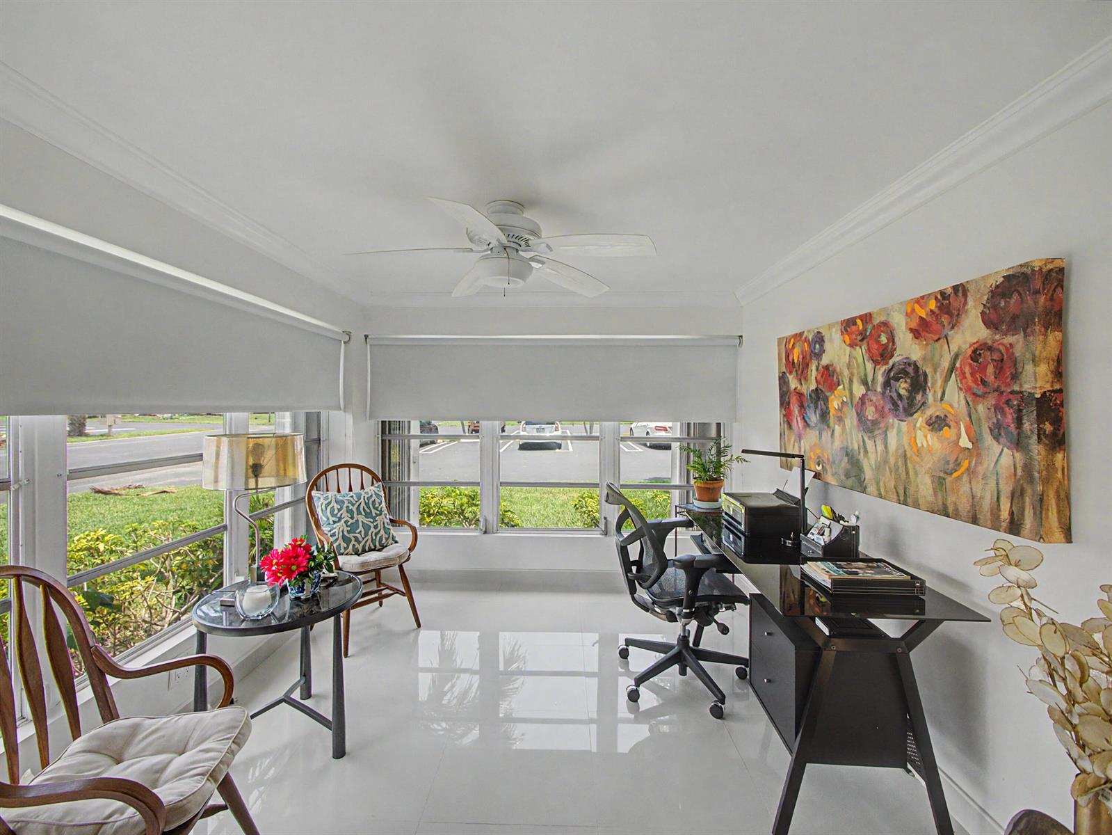 A home office features a glass desk, two wooden chairs, and a large floral painting — 4580 NW 3rd Street # D, Delray Beach FL 33445, DELRAY BEACH, FL