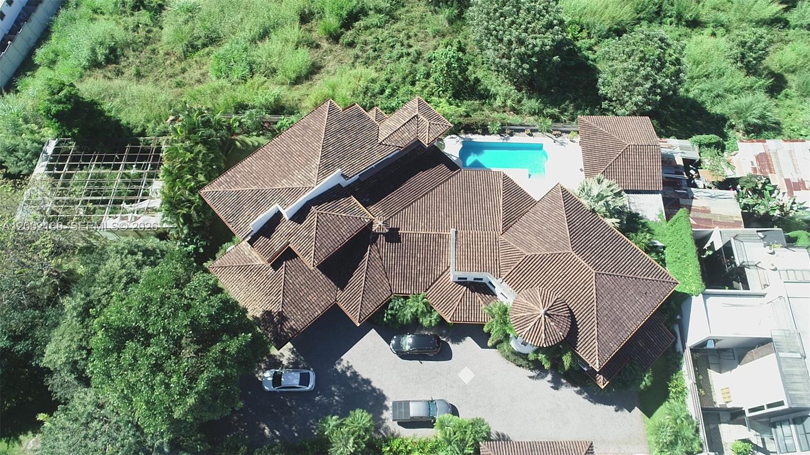 An aerial view shows a large house with a tiled roof, swimming pool, and driveway — Casa Guayabos Curridabat, San Jose, Costa Rica, FL, FL