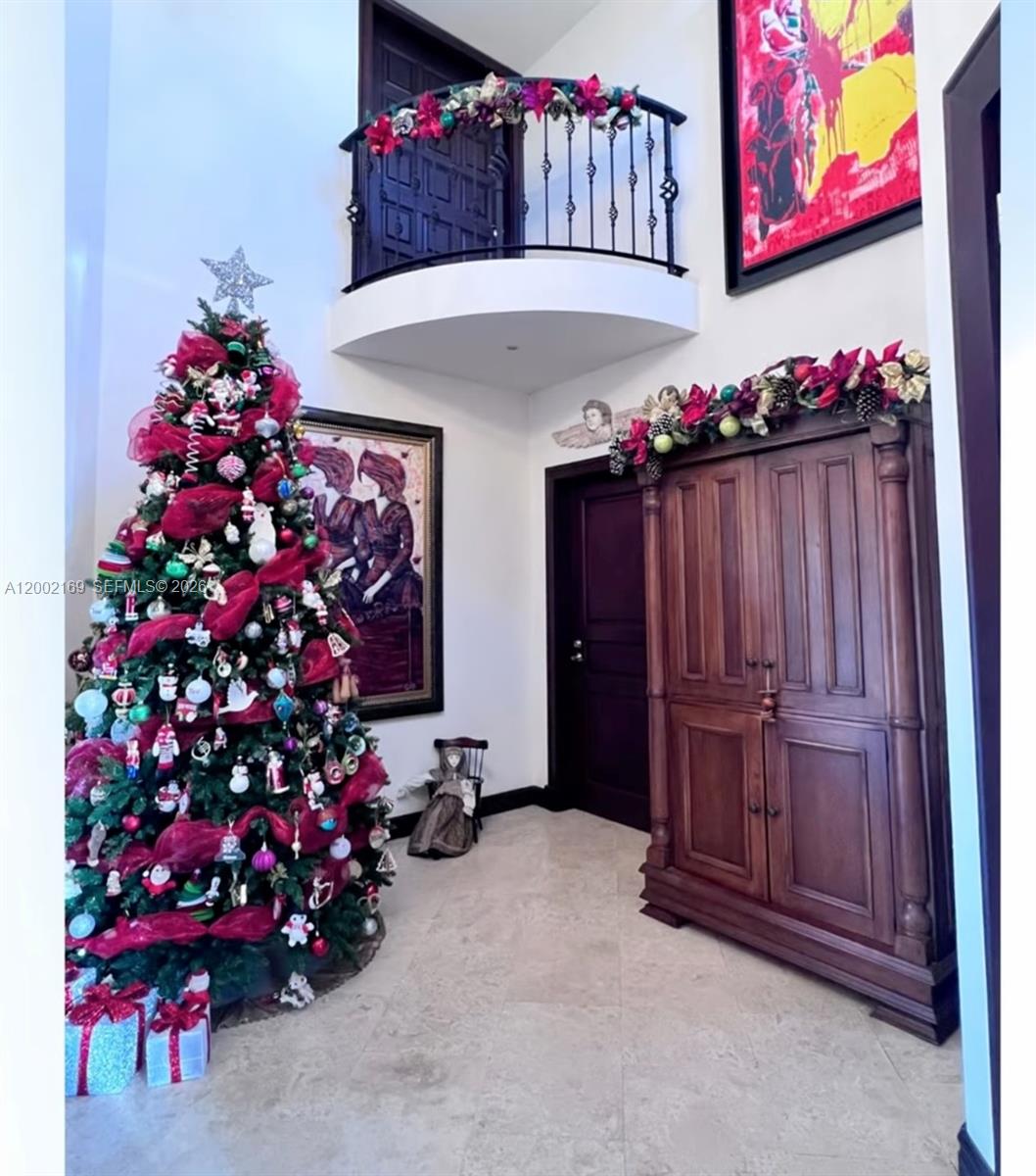 A high-ceilinged foyer features a decorated Christmas tree, a wooden armoire, and an interior balcony — Casa Guayabos Curridabat, San Jose, Costa Rica, FL, FL