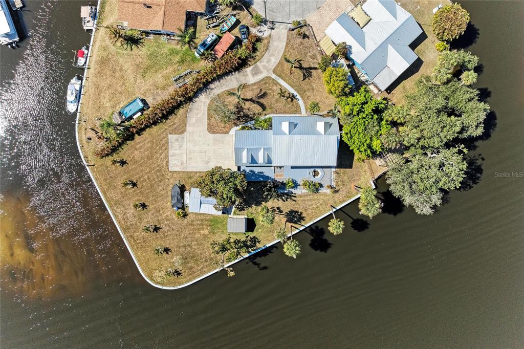 An aerial view shows a waterfront house with a metal roof and a boat dock — 9610 SW YACHT DRIVE, ARCADIA, FL