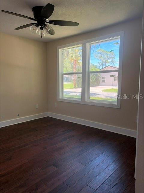 An empty room features dark wood-look flooring, a ceiling fan, and a large double window — 840 N FRANKFORT AVENUE, DELAND, FL