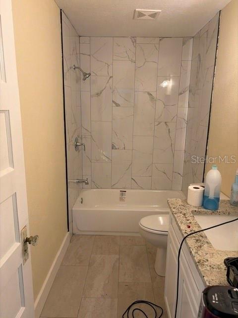 A bathroom features a white tub with marble-look tile walls and a granite-topped vanity — 840 N FRANKFORT AVENUE, DELAND, FL