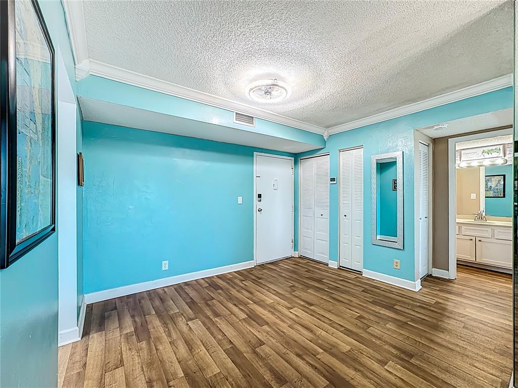 A room with turquoise walls, wood-look flooring, white doors, and a ceiling light fixture — 2901 26TH STREET W UNIT 511, BRADENTON, FL