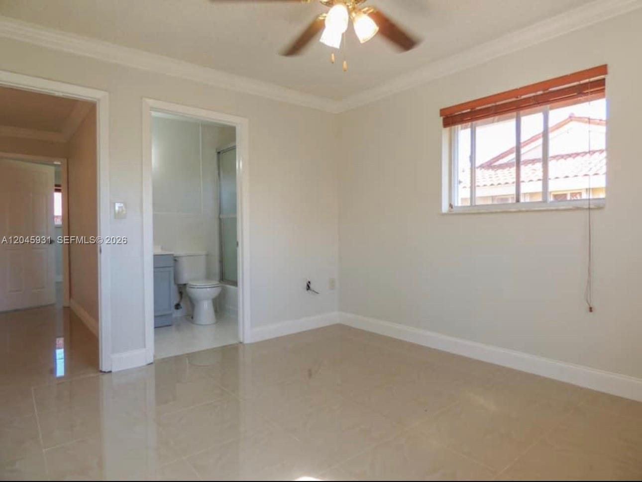 A bedroom with light-colored walls, tile flooring, a ceiling fan, and an attached bathroom — 8252 NW 6th Ter # 235, Miami FL 33126, MIAMI, FL