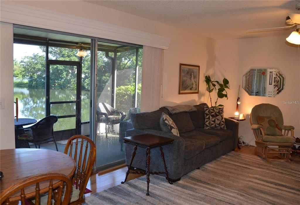 A living room features a blue sofa, a rocking chair, and a television on a stand — 1960 UNION STREET UNIT 19, CLEARWATER, FL