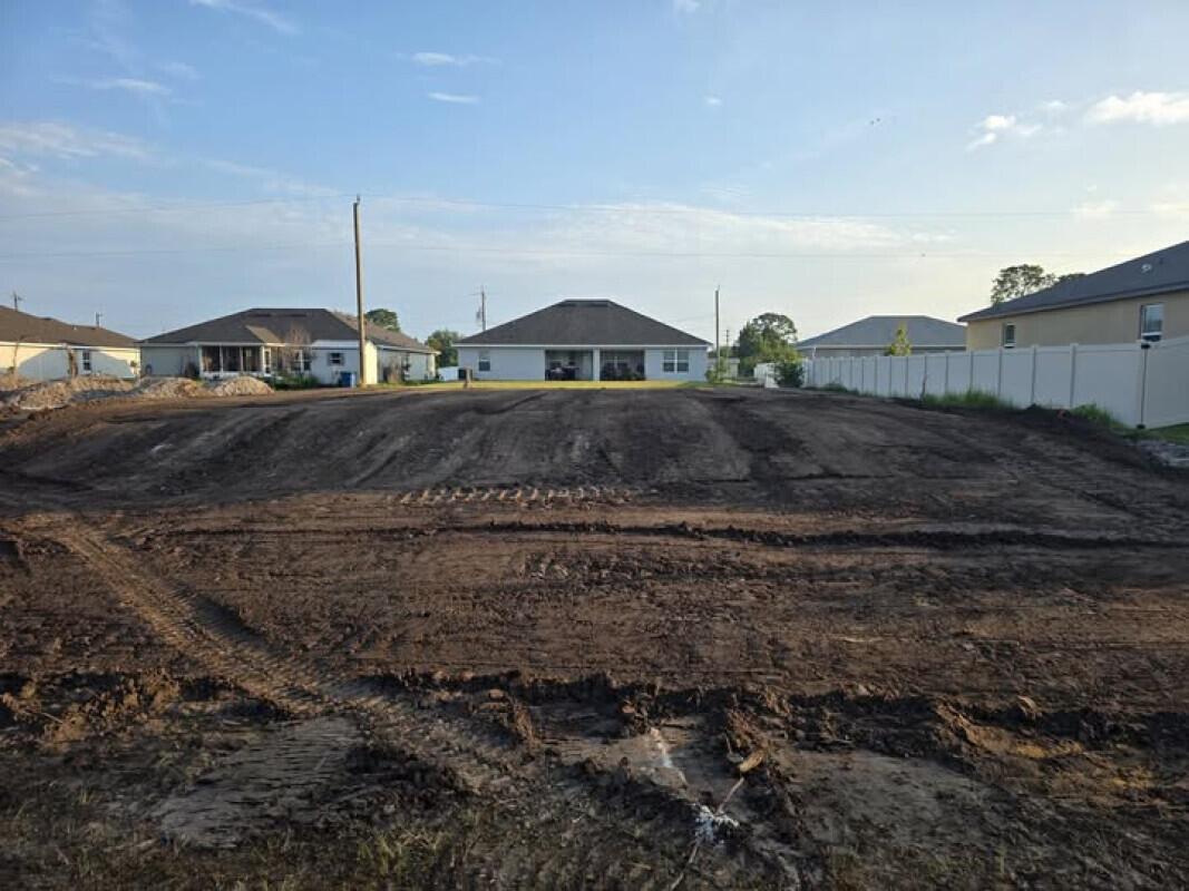 A cleared, vacant residential lot features tire tracks in the dirt under a blue sky — 519 Hancock Street, Palm Bay FL 32908, PALM BAY, FL