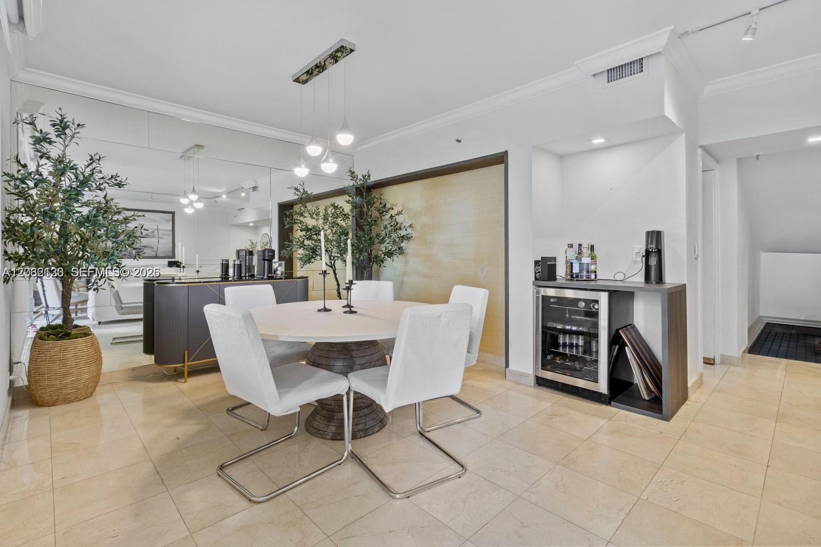 A dining area features a round table with white chairs, a mirrored wall, and a bar — 520 Brickell Key Dr # A307, Miami FL 33131, MIAMI, FL