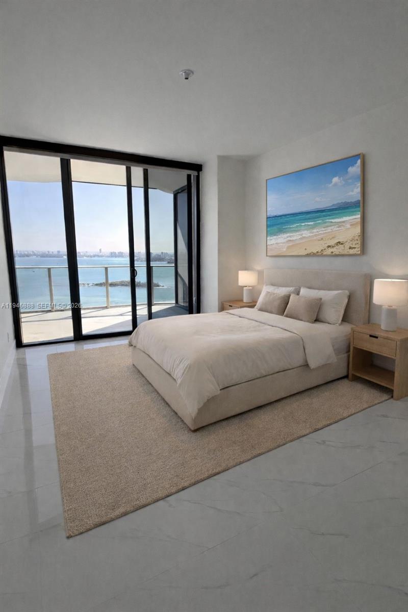 A modern bedroom features a bed, two nightstands, and floor-to-ceiling windows overlooking the ocean — 700 NE 24TH # 3105, Miami FL 33137, MIAMI, FL