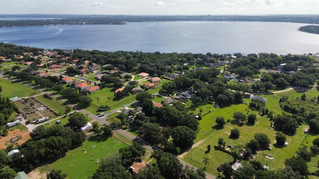 An aerial view shows a residential neighborhood situated along the shore of a large lake — 11750 COUNTY ROAD 561, CLERMONT, FL