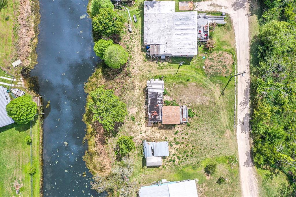 An aerial view shows several structures on a rural lot adjacent to a canal — 3386 MAPLE LANE, HAINES CITY, FL