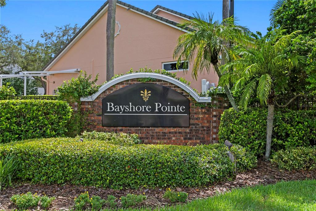 A brick monument sign for Bayshore Pointe sits in front of a peach-colored building — 2801 SHORE BREEZE DRIVE, TAMPA, FL