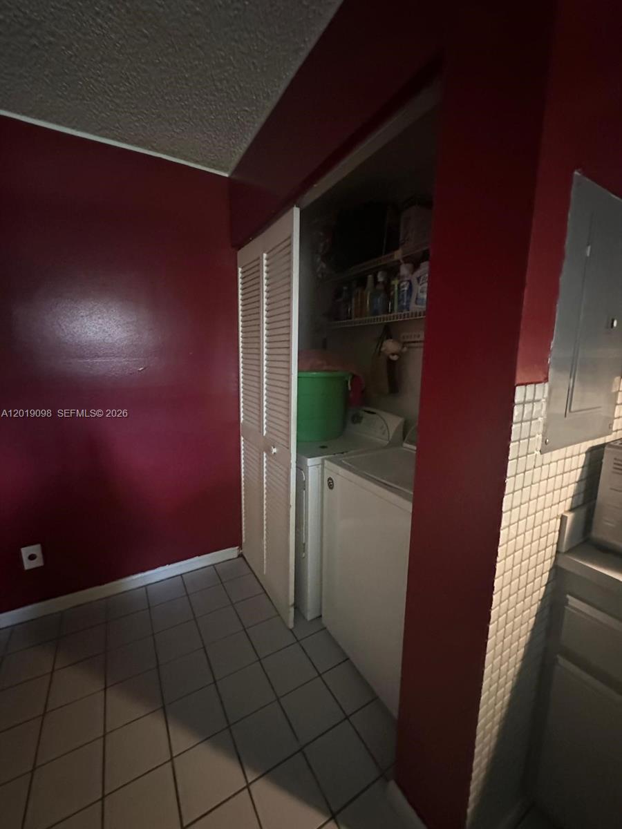 A laundry closet with a washer and dryer is set against a red wall — 3622 NW 95th Ter # 2L, Sunrise FL 33351, SUNRISE, FL