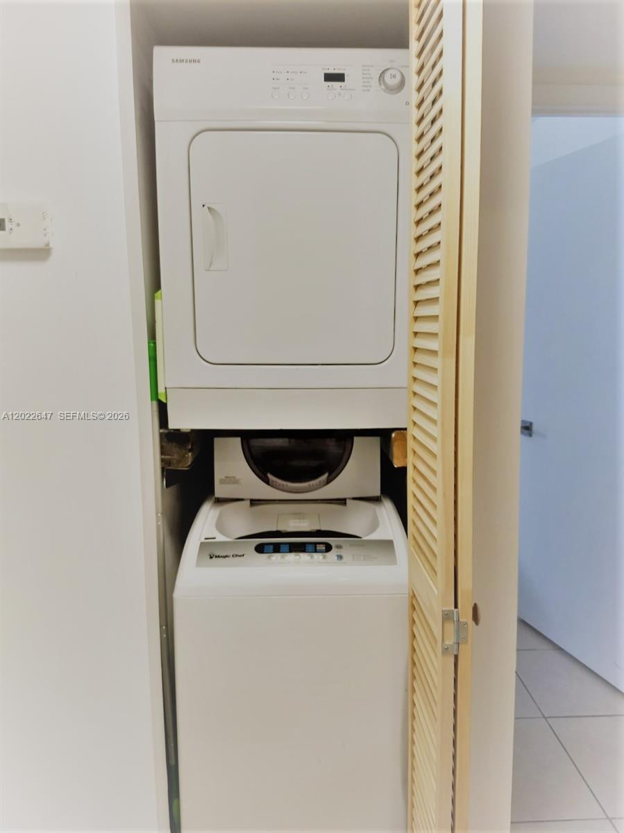 A laundry closet contains a stacked Samsung dryer and a Magic Chef top-load washing machine — 14857 SW 104th St # 201, Miami FL 33196, MIAMI, FL