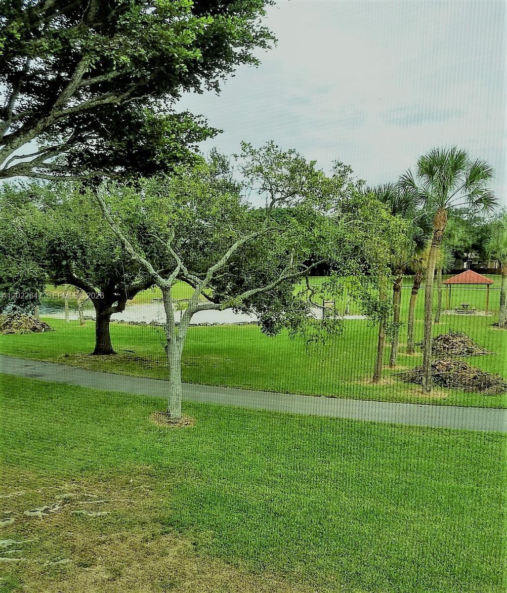 A view of a grassy park with trees, a walking path, and a small gazebo — 14857 SW 104th St # 201, Miami FL 33196, MIAMI, FL