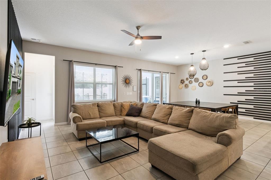 A living room features a large sectional sofa, a coffee table, and a dining area — 262 MARCELLO BOULEVARD, KISSIMMEE, FL