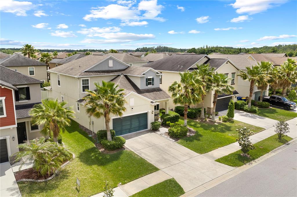 An aerial view shows a two-story suburban house with a garage and palm trees — 1588 LUDINGTON AVENUE, WESLEY CHAPEL, FL