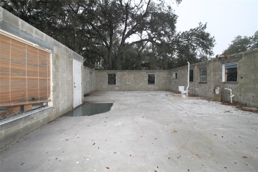 An open-air concrete block structure with a concrete floor, a single door, and a toilet — 8725 TREASURE ISLAND ROAD, LEESBURG, FL