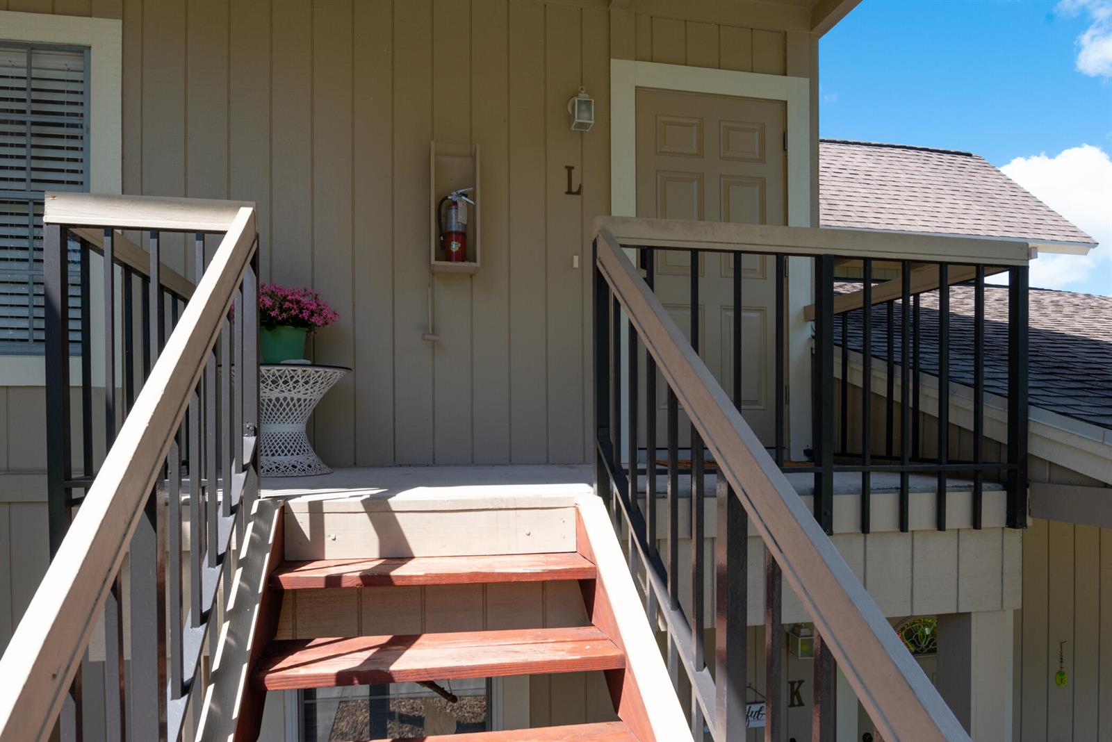 Exterior view of a wooden staircase leading to a second-floor apartment entrance marked L — 9130 SE Riverfront Terrace # L, Jupiter FL 33469, JUPITER, FL