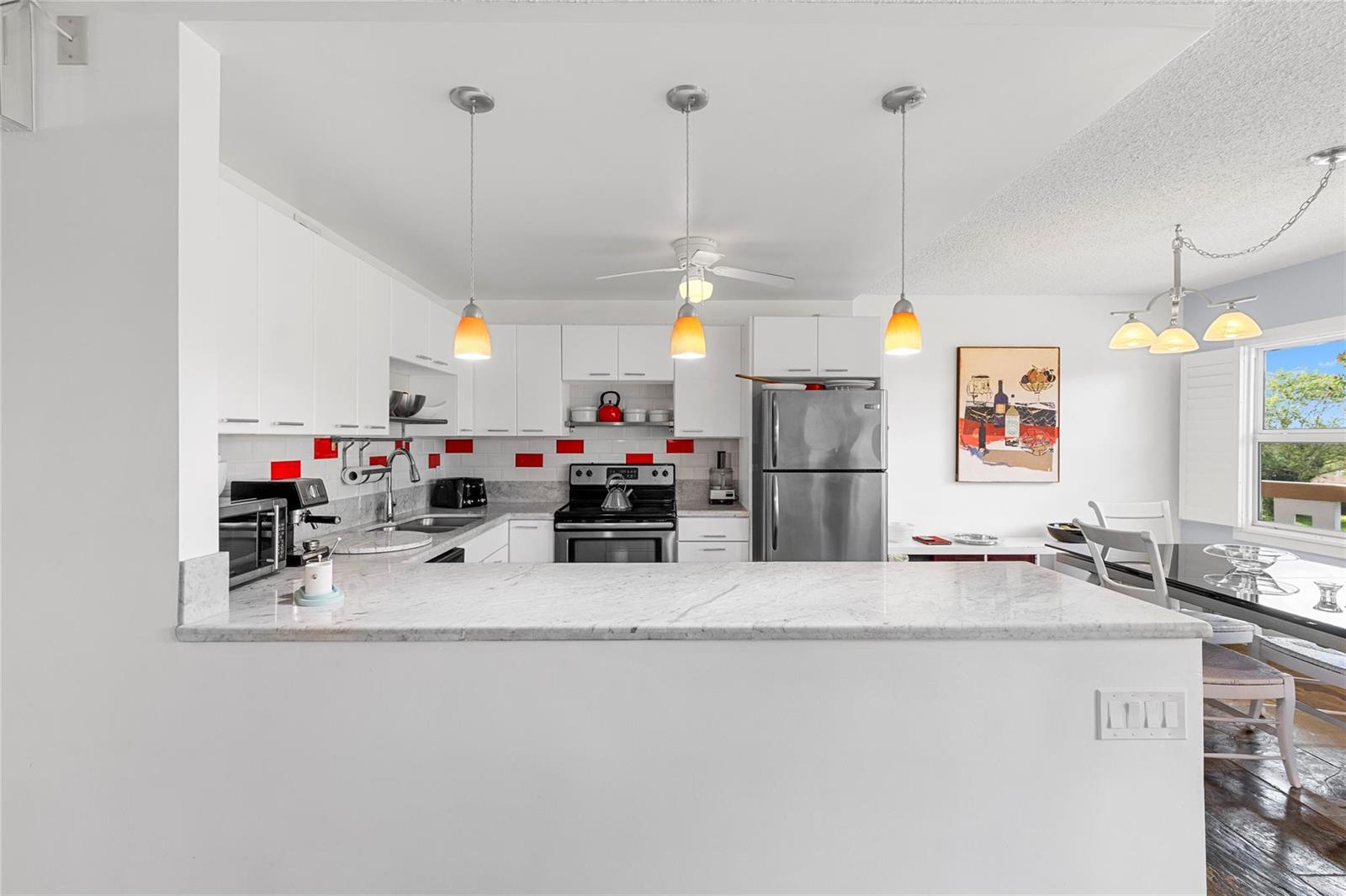 A kitchen with white cabinets, stainless steel appliances, and a marble-topped breakfast bar — 4044 Ventnor O # 4044, Deerfield Beach FL 33442, DEERFIELD BEACH, FL