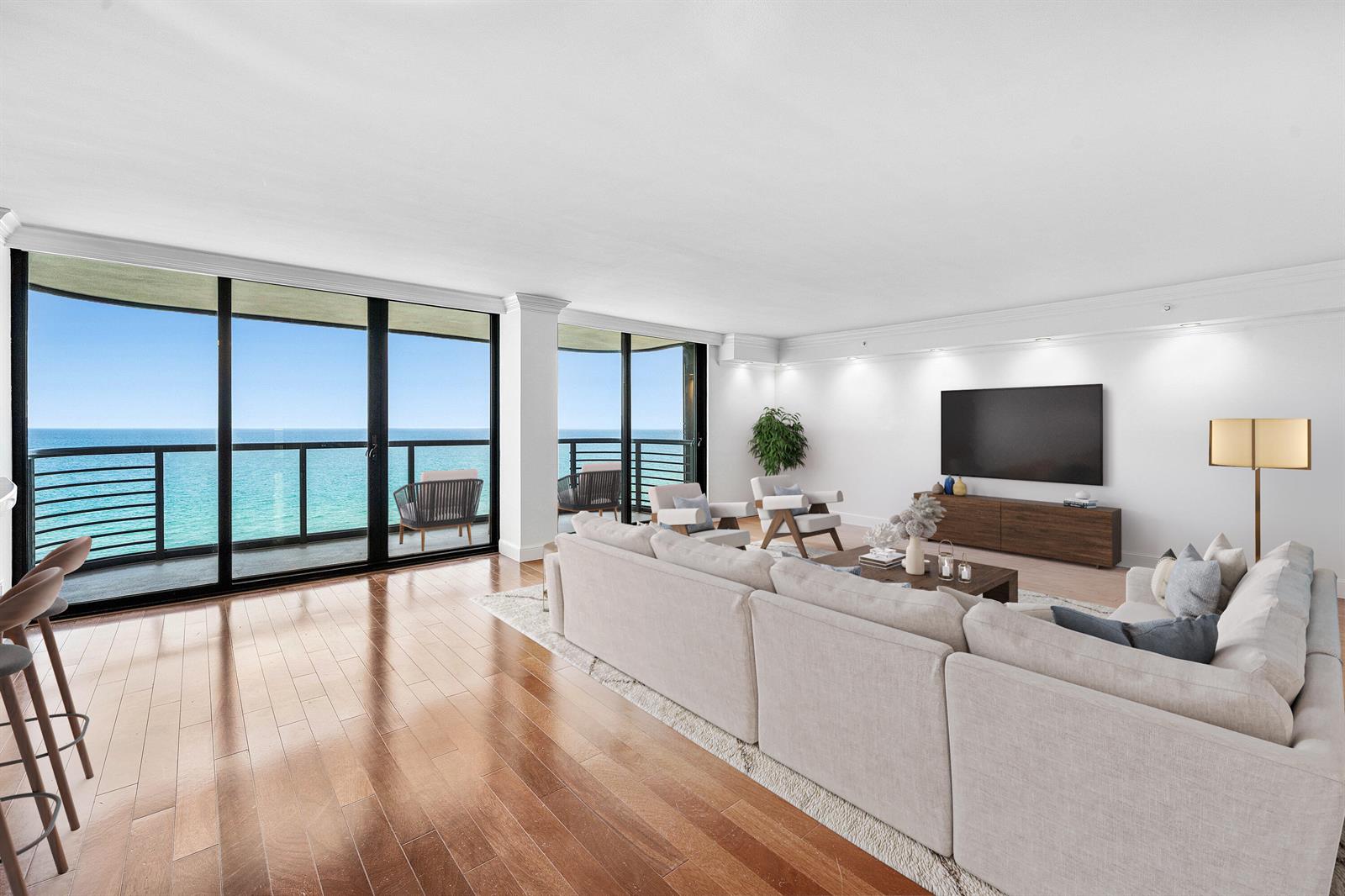 A living room with hardwood floors, a large sectional, and floor-to-ceiling windows overlooking the ocean — 250 S Ocean Boulevard # 11c, Boca Raton FL 33432, BOCA RATON, FL
