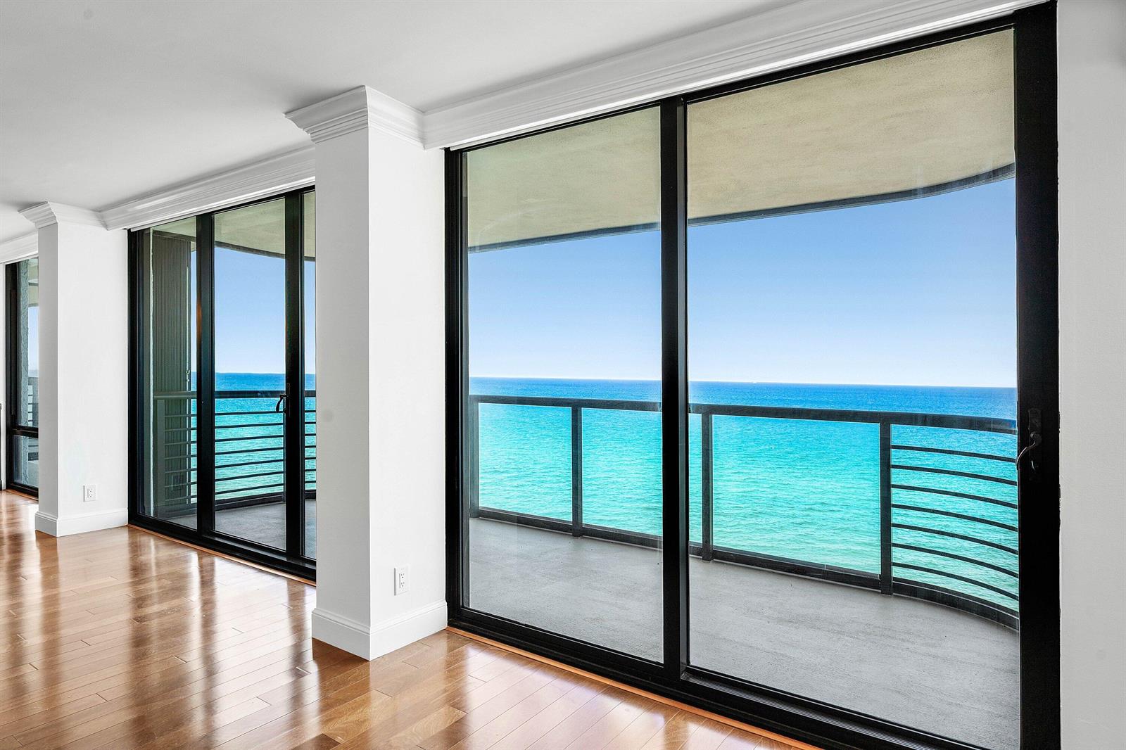 A room with hardwood floors and large sliding glass doors opening to an oceanfront balcony — 250 S Ocean Boulevard # 11c, Boca Raton FL 33432, BOCA RATON, FL