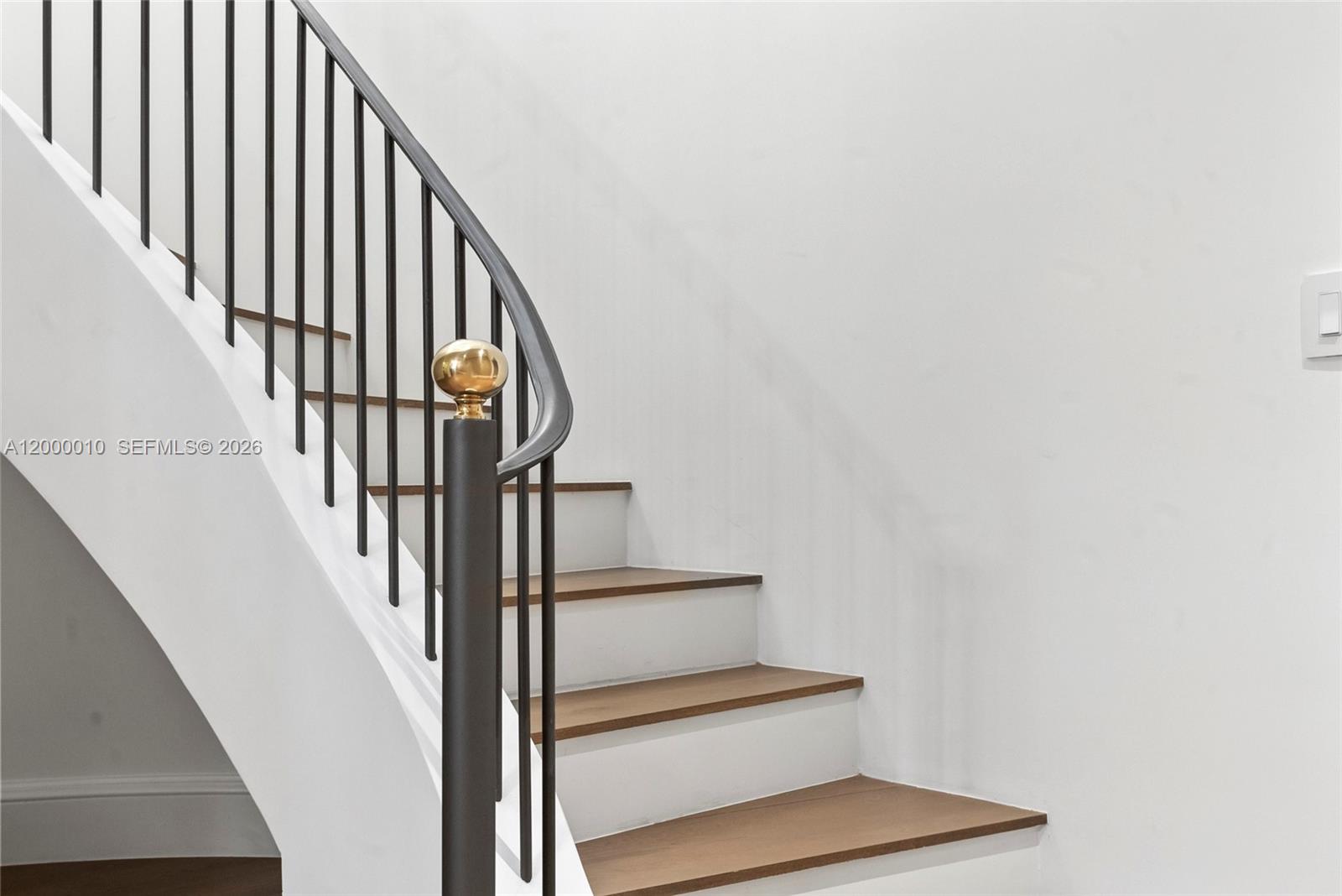 A staircase features wooden treads, white risers, and a black metal railing with a brass finial — 2617 Anderson Rd, Coral Gables FL 33134, CORAL GABLES, FL