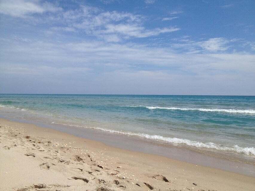 A sandy beach meets the blue ocean under a partly cloudy sky — 5550 Osprey Drive, Ocean Ridge FL 33435, OCEAN RIDGE, FL