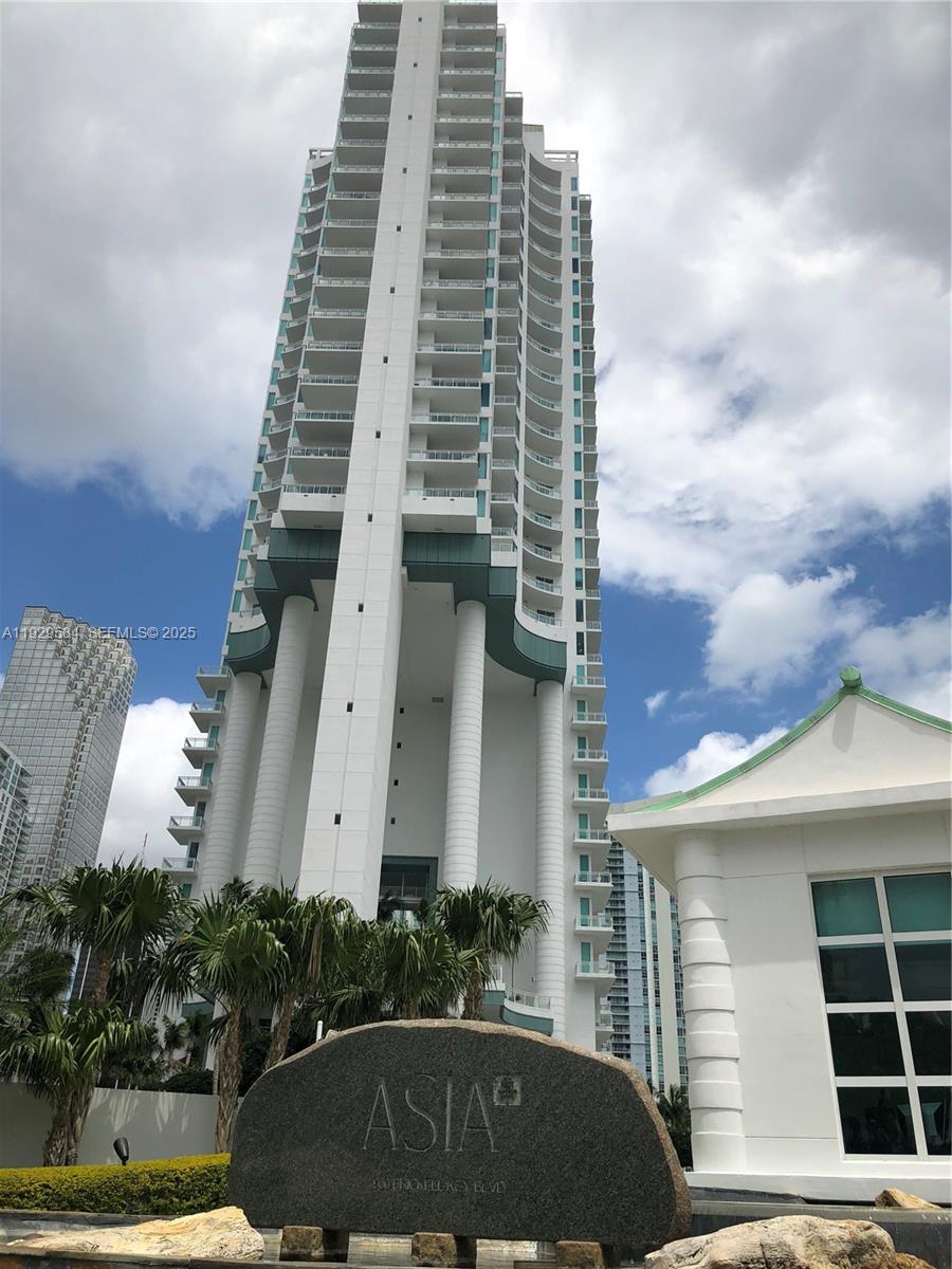 A tall white residential skyscraper stands behind a stone sign labeled Asia — 900 Brickell Key Blvd # 1602, Miami FL 33131, MIAMI, FL