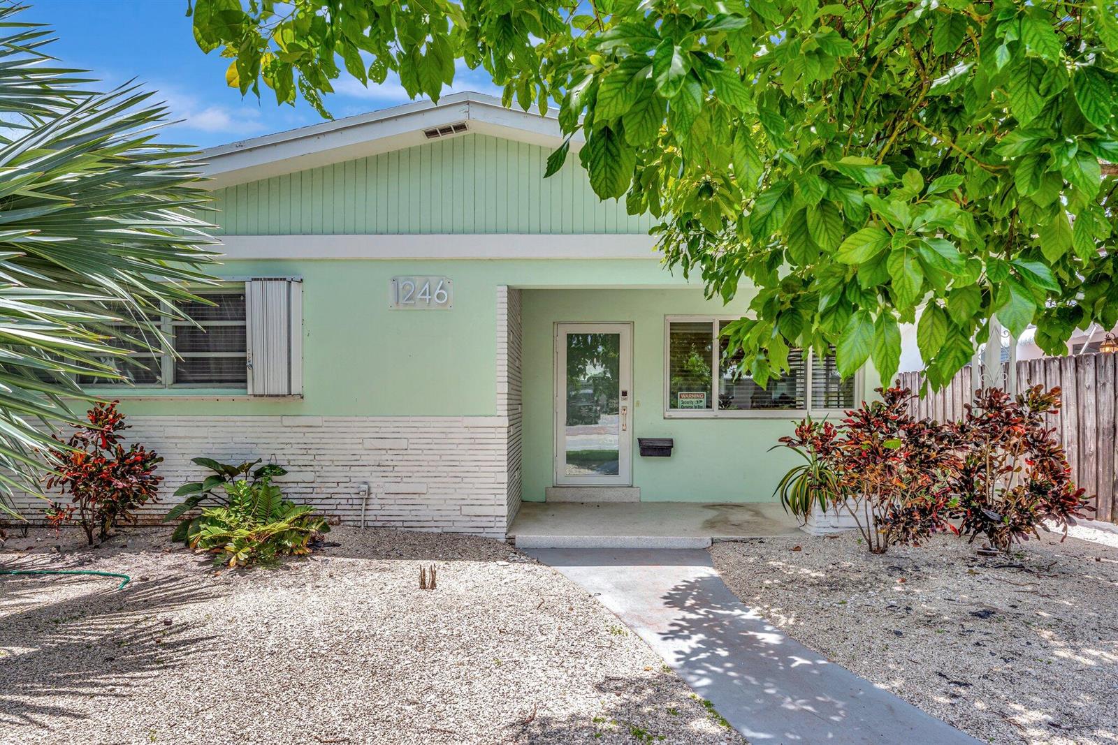 A light green house with a white brick base and a gravel front yard — 1246 Johnson Street, Hollywood FL 33019, HOLLYWOOD, FL