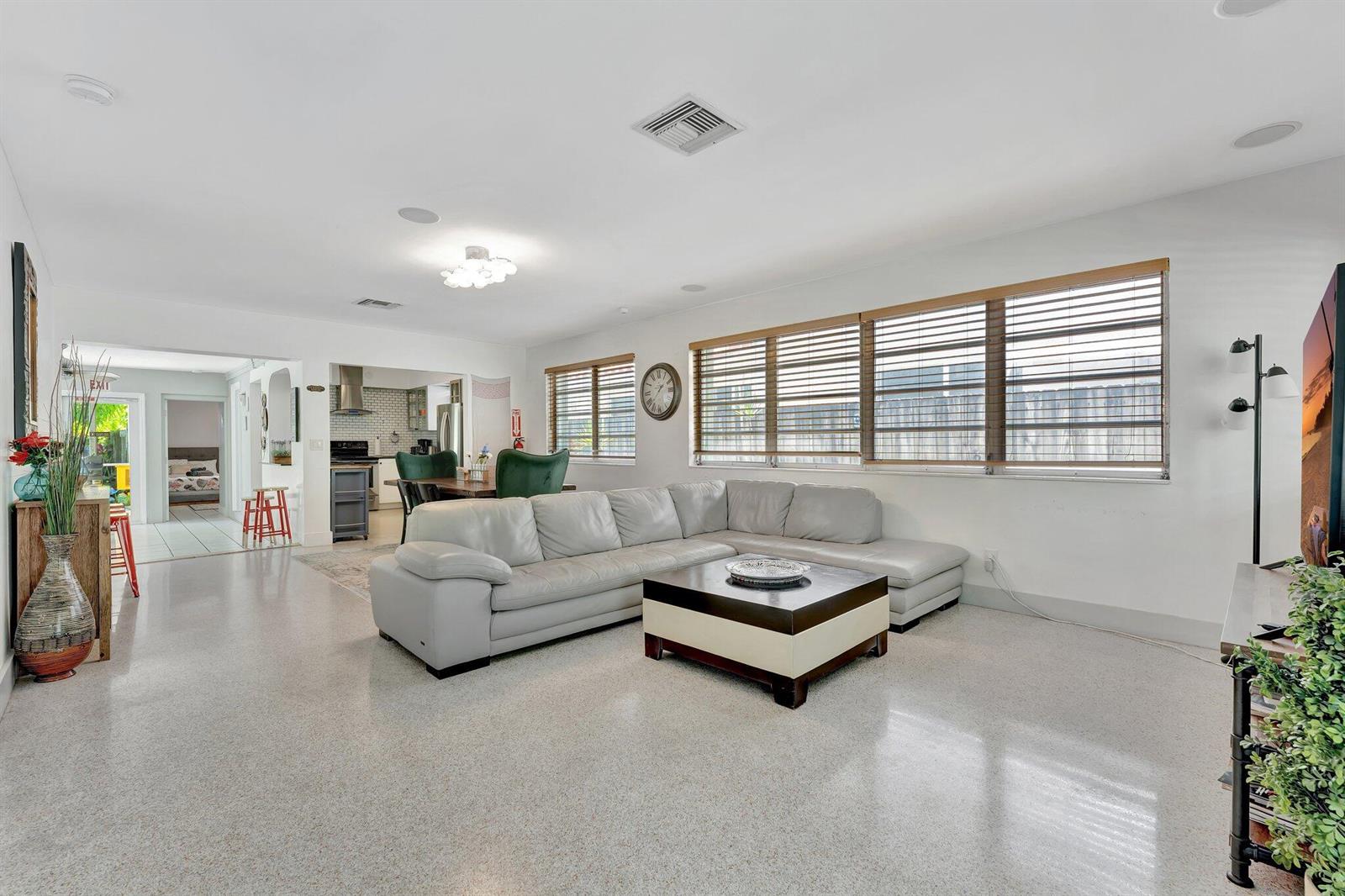 A living room with a light gray sectional sofa, a coffee table, and terrazzo flooring — 1246 Johnson Street, Hollywood FL 33019, HOLLYWOOD, FL