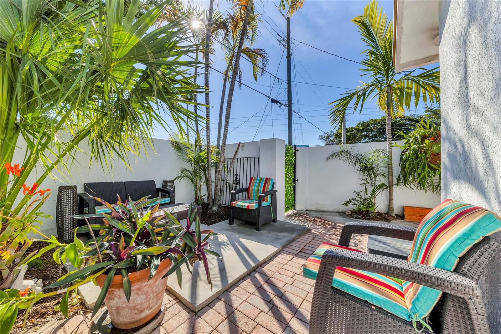 A patio features a brick floor, a concrete pad, outdoor furniture, and palm trees — 307 N Highland Drive, Hollywood FL 33021, HOLLYWOOD, FL