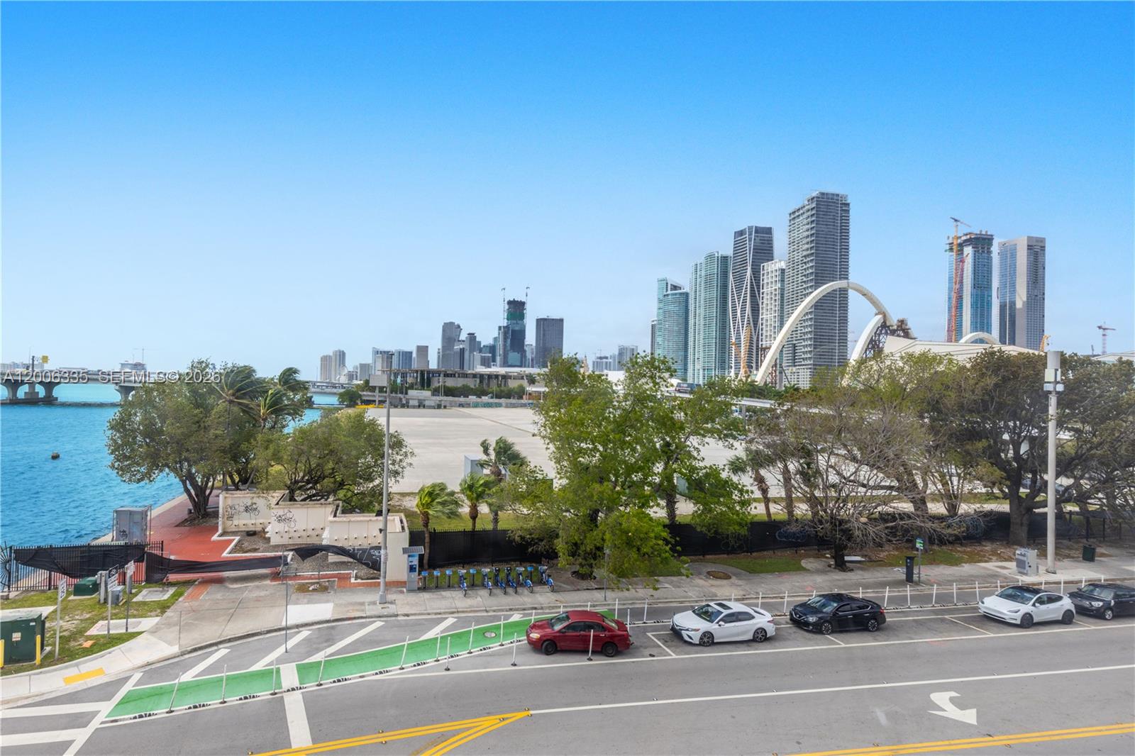 An elevated view shows a city skyline, a large vacant lot, and a waterfront park — 555 NE 15th St # 501, Miami FL 33132, MIAMI, FL