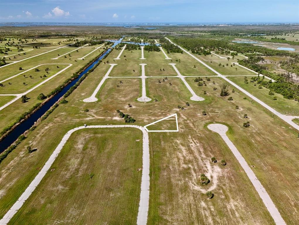 An aerial view shows a vacant residential lot outlined in white within a developing subdivision — 12384 BONITA PLACE, PLACIDA, FL