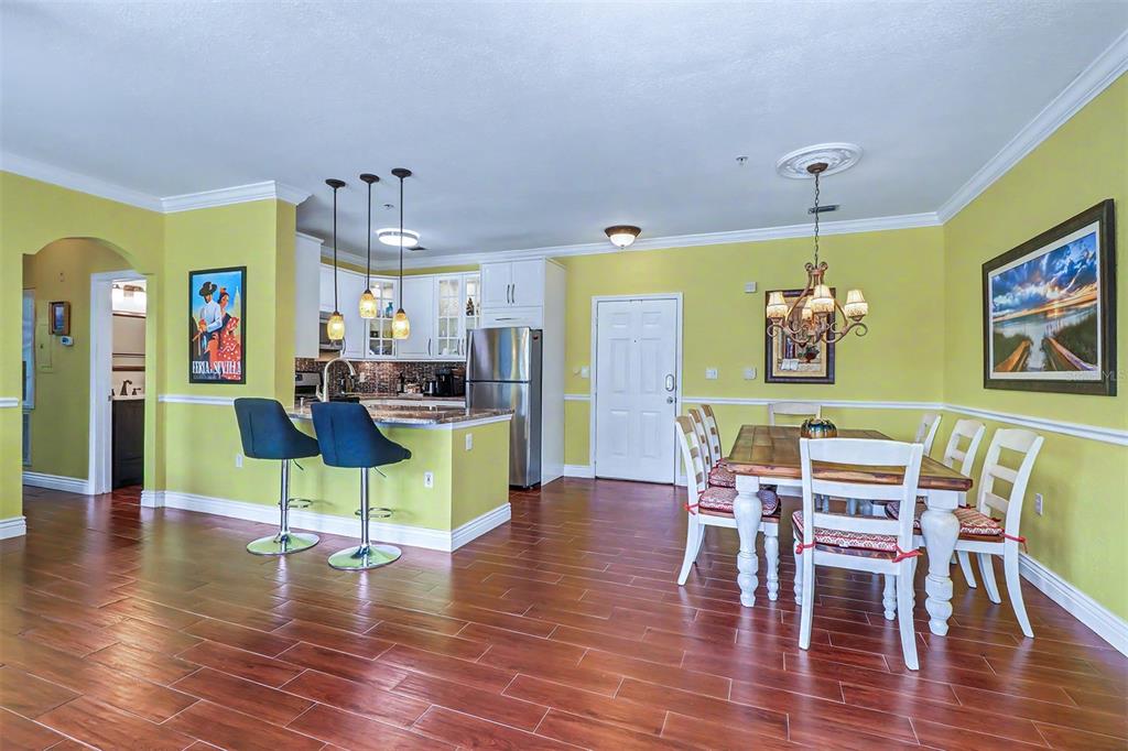 A multi-story residential building with orange stucco walls, multiple garage doors, and arched windows — 2746 VIA TIVOLI UNIT 122B, CLEARWATER, FL