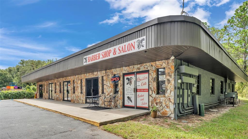 A single-story commercial building with a stone facade, a dark metal roof, and glass doors — 4314 N SUNCOAST BOULEVARD, CRYSTAL RIVER, FL