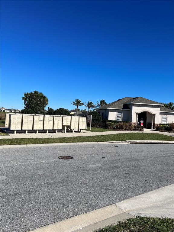 A row of metal mailboxes stands on a concrete pad near a community building — 604 SARNER PASS WAY, WINTER HAVEN, FL