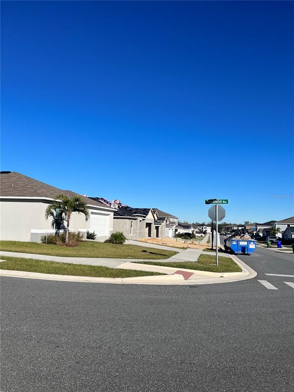 A street view shows a residential neighborhood with new houses, a dumpster, and street signs — 604 SARNER PASS WAY, WINTER HAVEN, FL