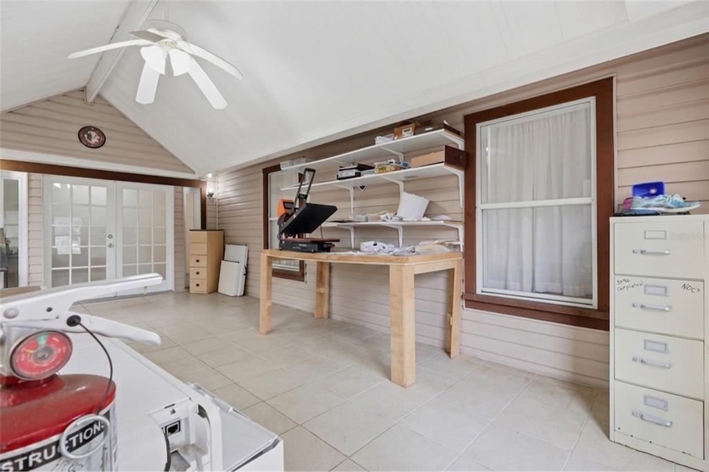 A sunroom features tile flooring, a vaulted ceiling with a fan, and a wooden workbench — 11808 FAWN DALE DRIVE, RIVERVIEW, FL