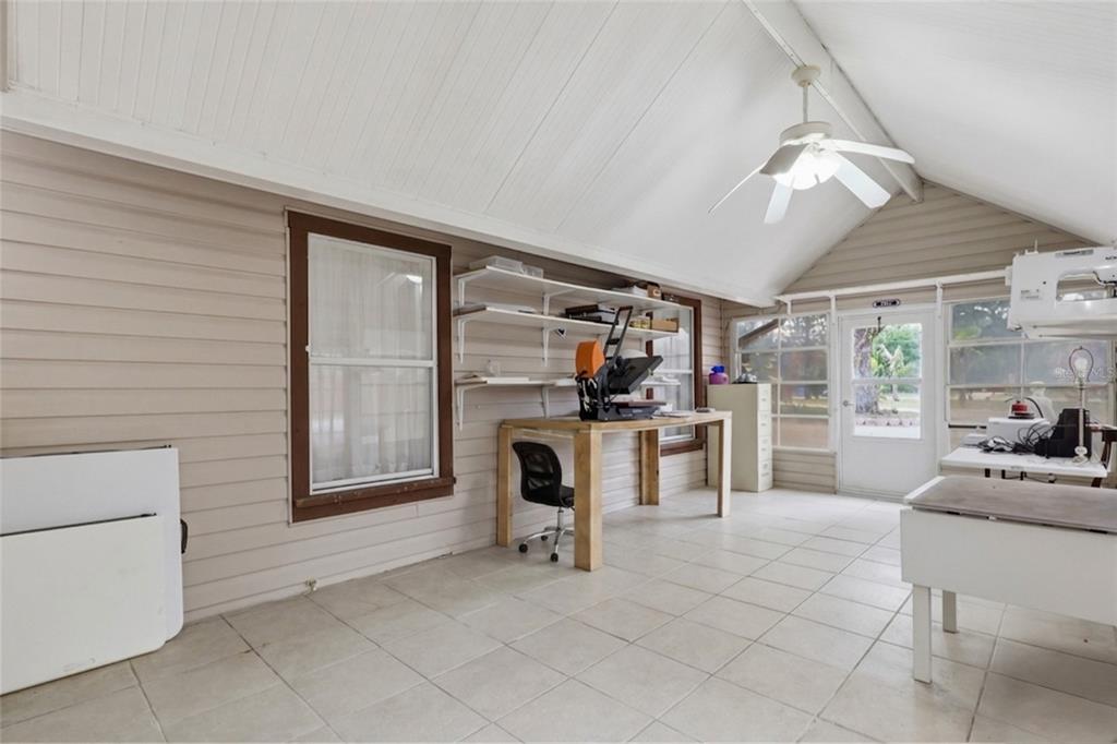 A sunroom with tile flooring, a vaulted ceiling, a ceiling fan, and craft work tables — 11808 FAWN DALE DRIVE, RIVERVIEW, FL