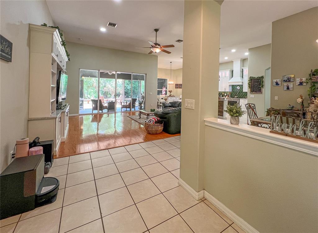 A view from a tiled entryway looking into a living room with hardwood floors — 9046 SHENANDOAH RUN, WESLEY CHAPEL, FL