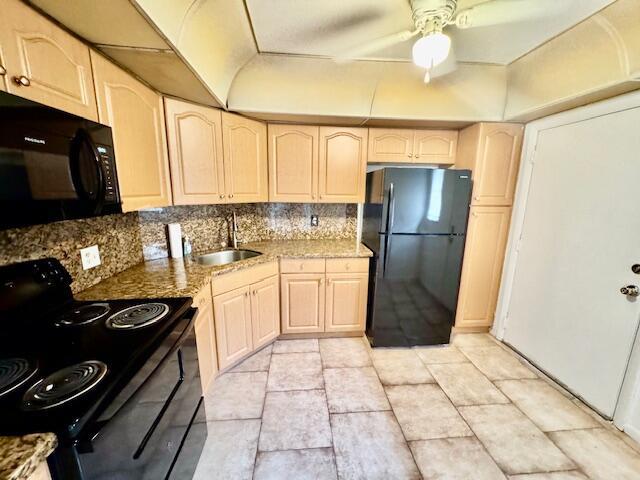 A kitchen features light wood cabinets, black appliances, granite countertops, and tiled flooring — 3300 Spanish Moss Terrace # 302, Lauderhill FL 33319, LAUDERHILL, FL
