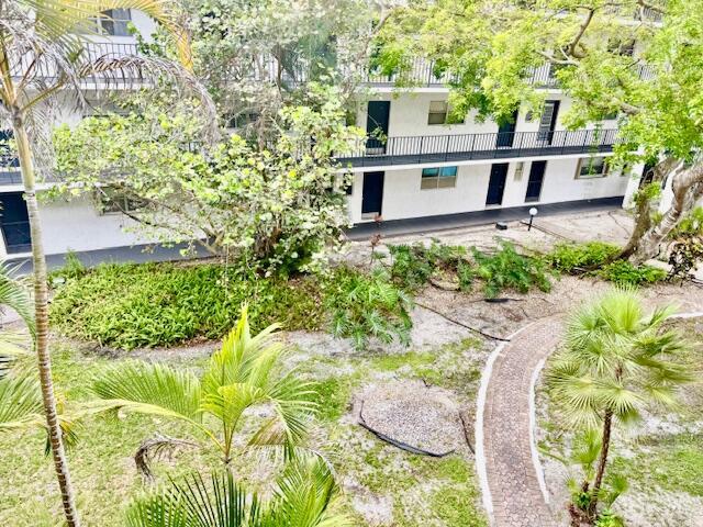 An elevated view shows a white multi-story apartment building with a brick walkway and landscaping — 3300 Spanish Moss Terrace # 302, Lauderhill FL 33319, LAUDERHILL, FL