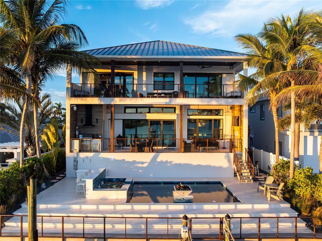 A three-story waterfront home features a swimming pool, a patio, and multiple balconies — 459 20TH AVENUE, INDIAN ROCKS BEACH, FL